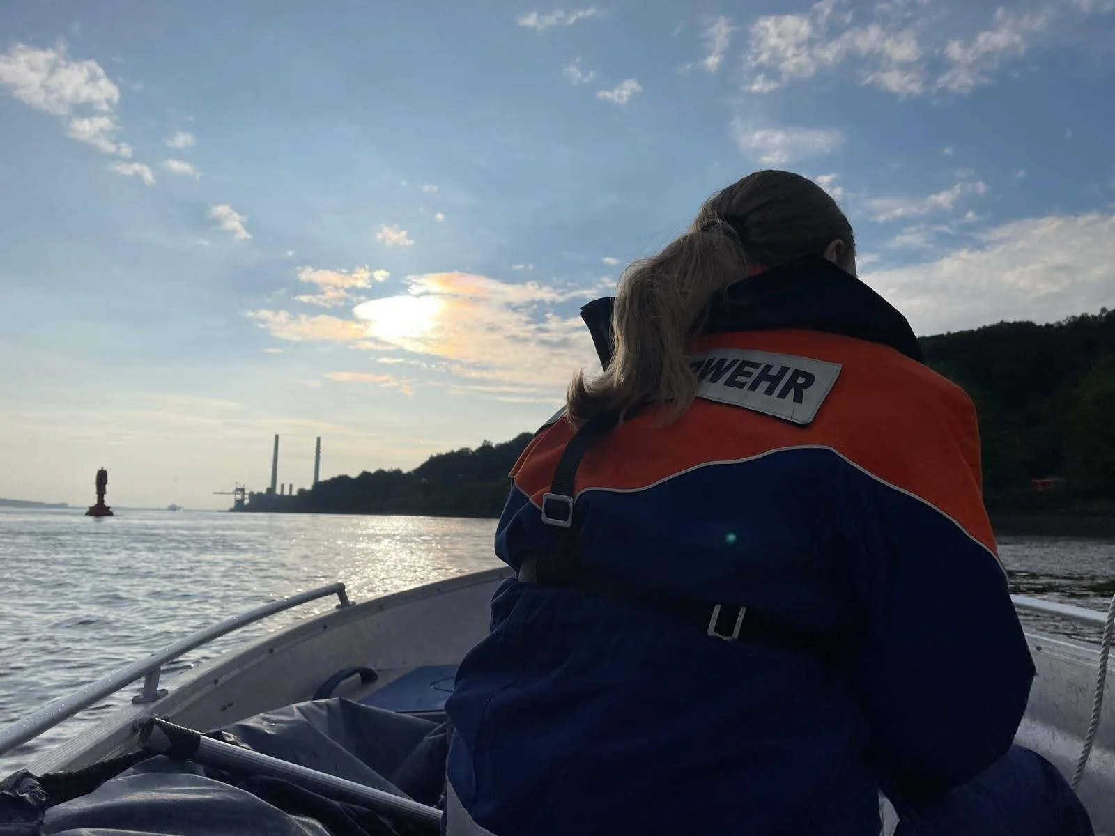Bootsbesatzung bei Sonnenuntergang auf der Unterelbe